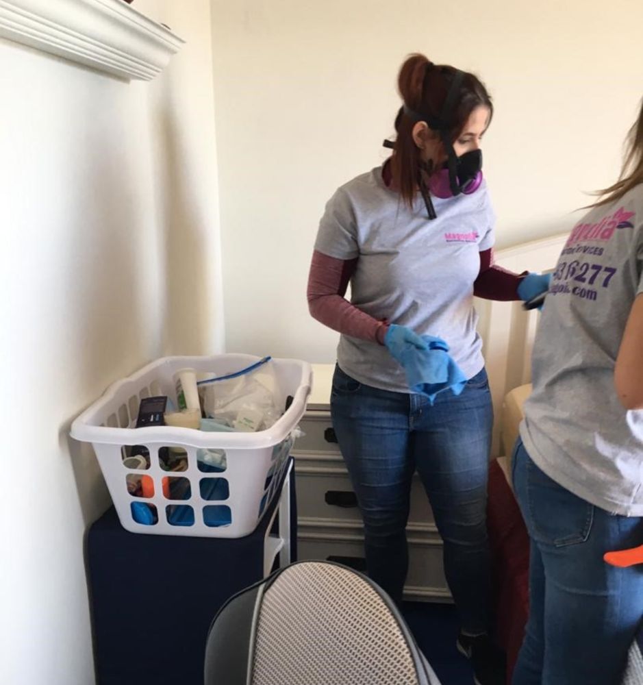 Magnolia technicians in respirators cleaning a room after a fire